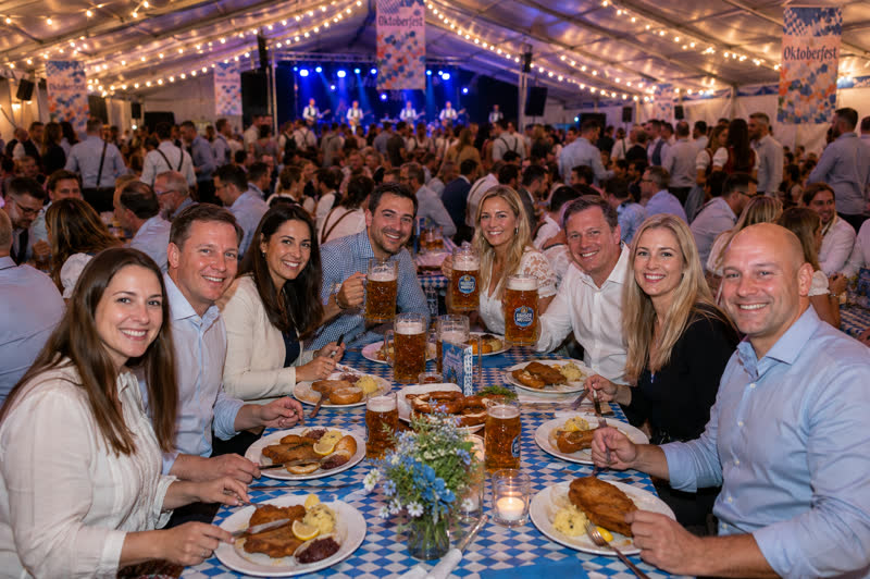 Corporate group at an Oktoberfest table with food and beers
